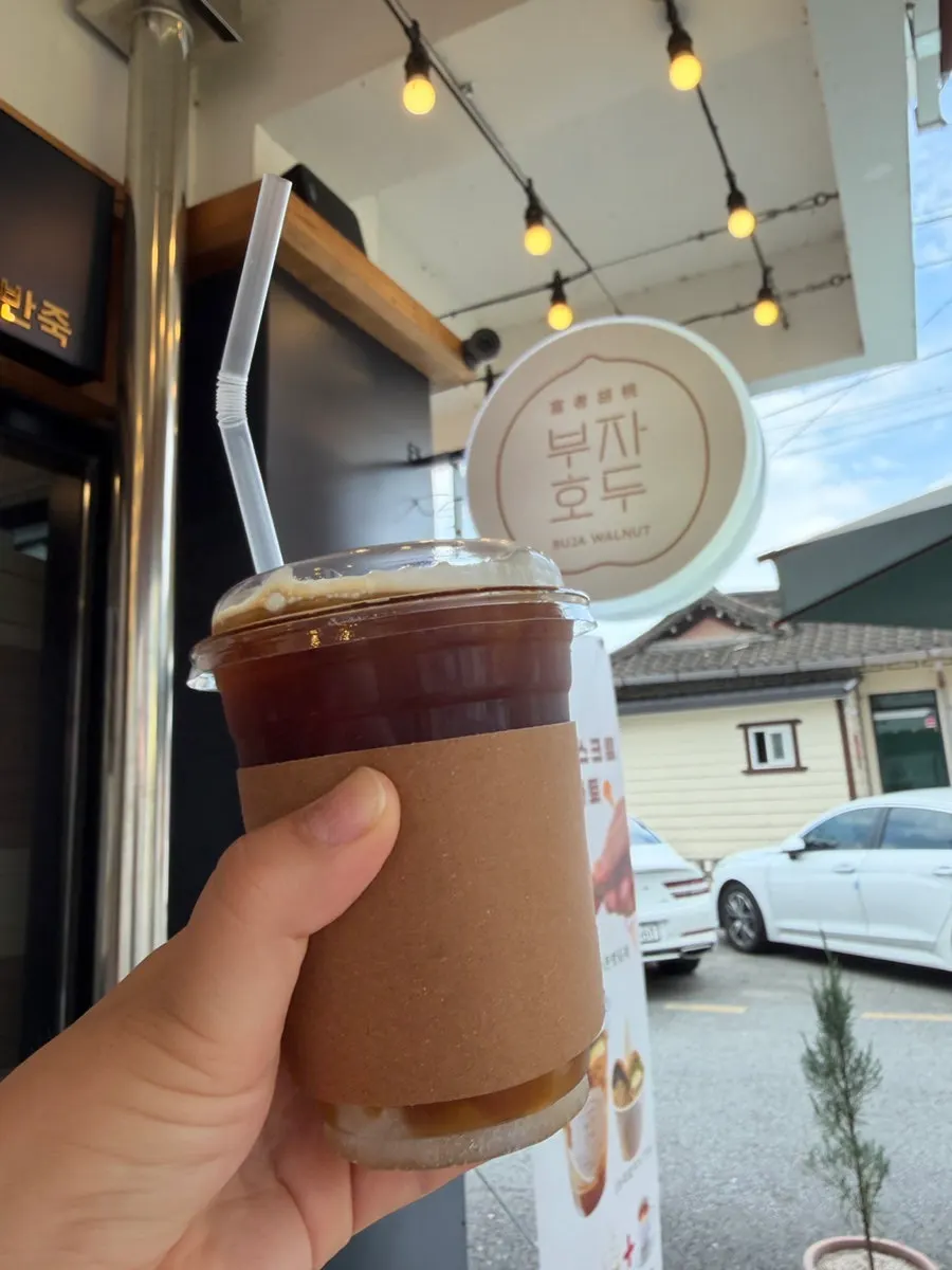 Box of walnut pastries next to an iced americano
