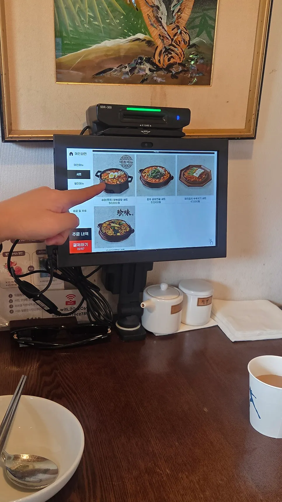Kiosk ordering screen with seating in the background