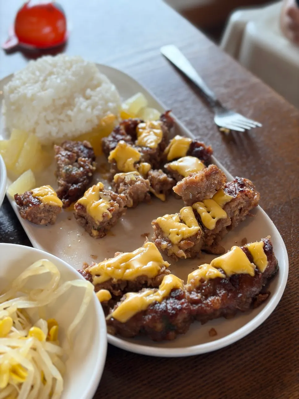 A spread of Sumi chicken stew, egg rice, and cheese tteokgalbi