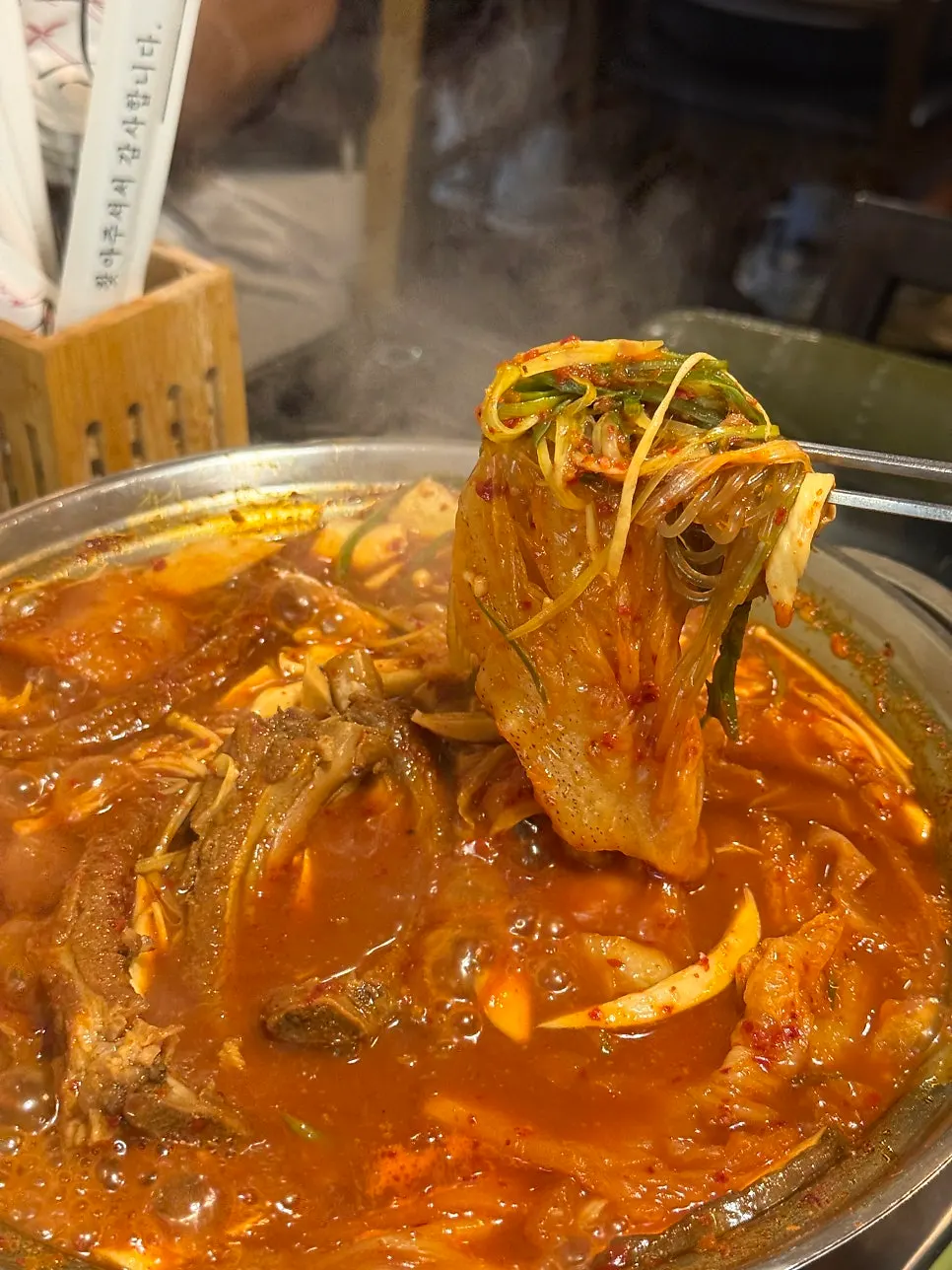 Eating rib topped with aged kimchi and shredded green onion