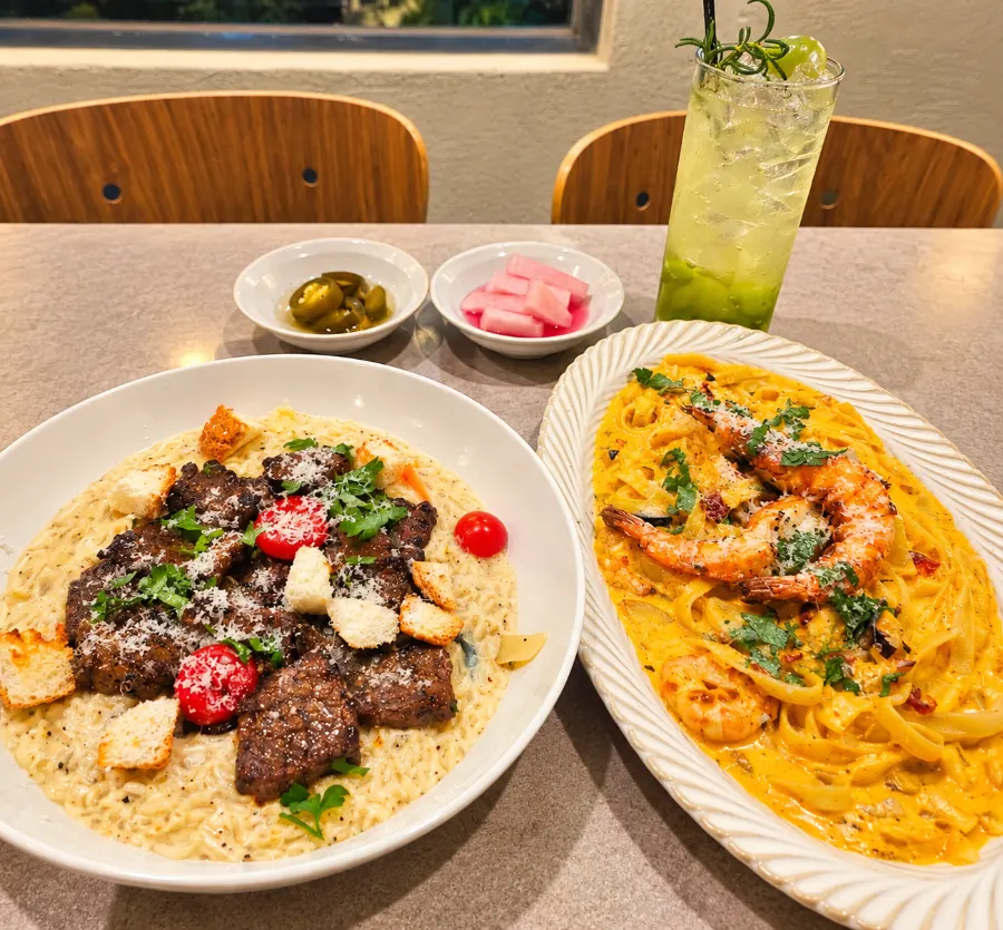 ビーフリゾットとトゥームバパスタ、青ぶどうエードが並んだ食卓