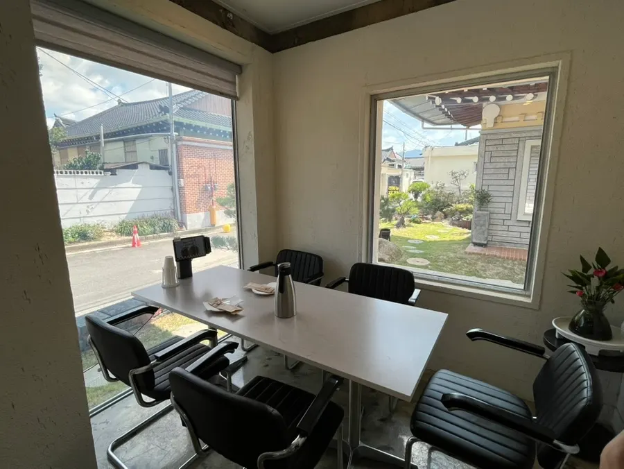 Window-side table at Midam Kitchen with a hanok and garden view