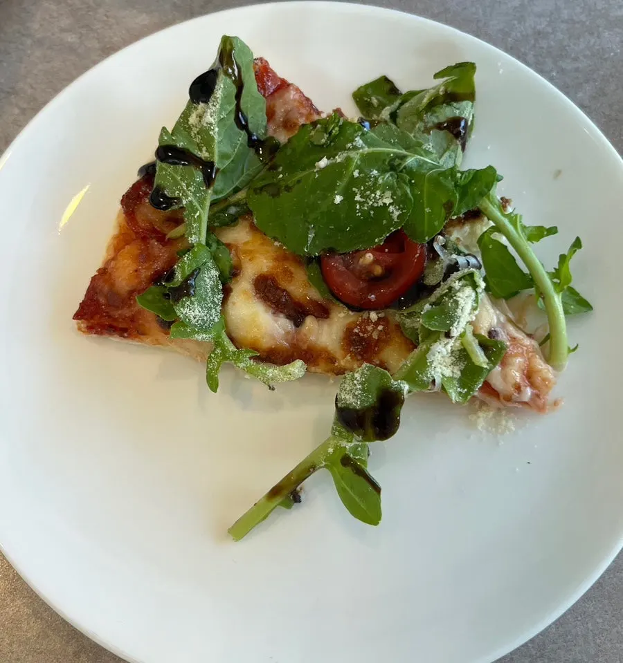 Arugula pizza with visible cherry tomatoes