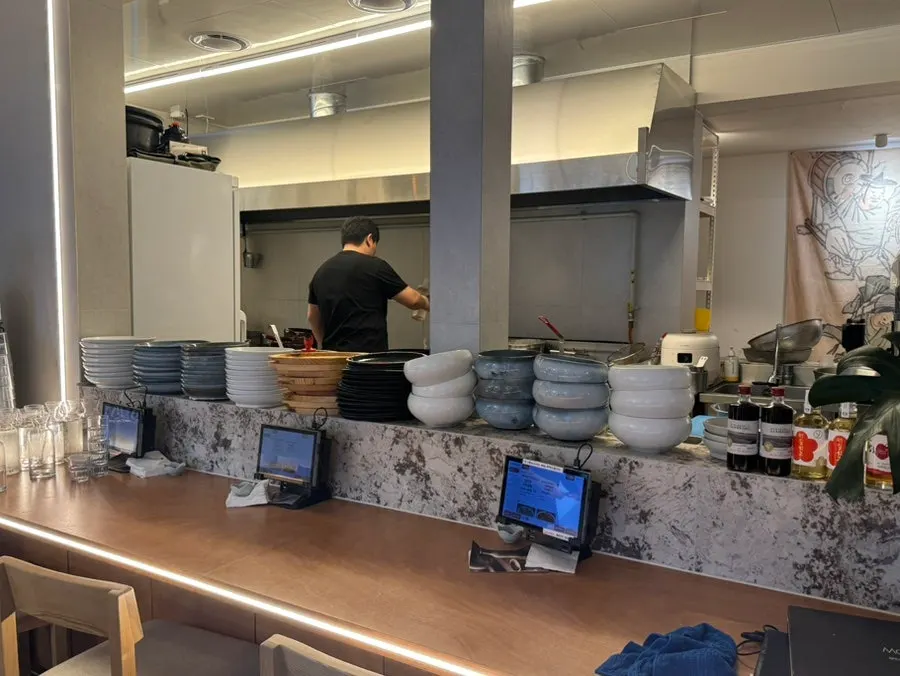 Interior with table and counter seats around an open kitchen