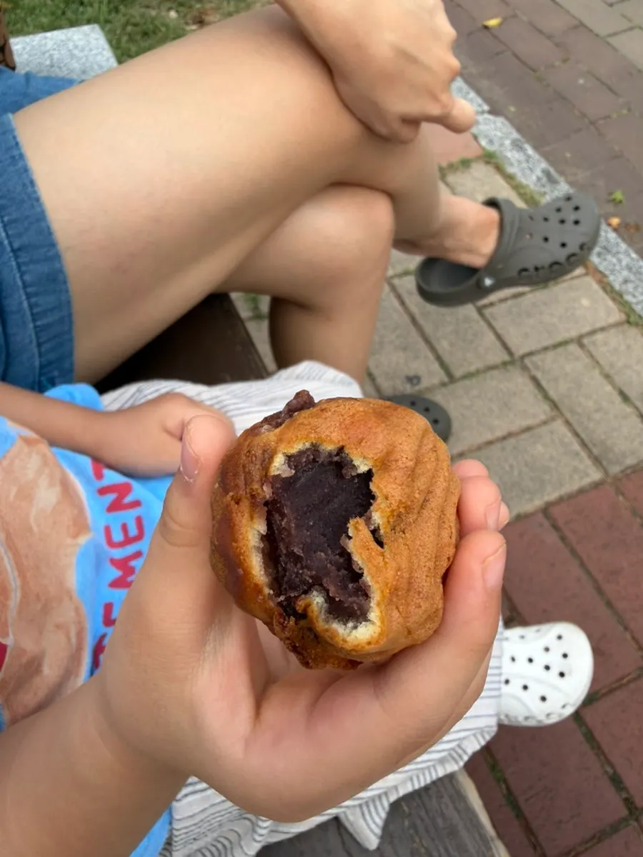 Cross-section of a walnut pastry showing the plump walnut and red bean filling