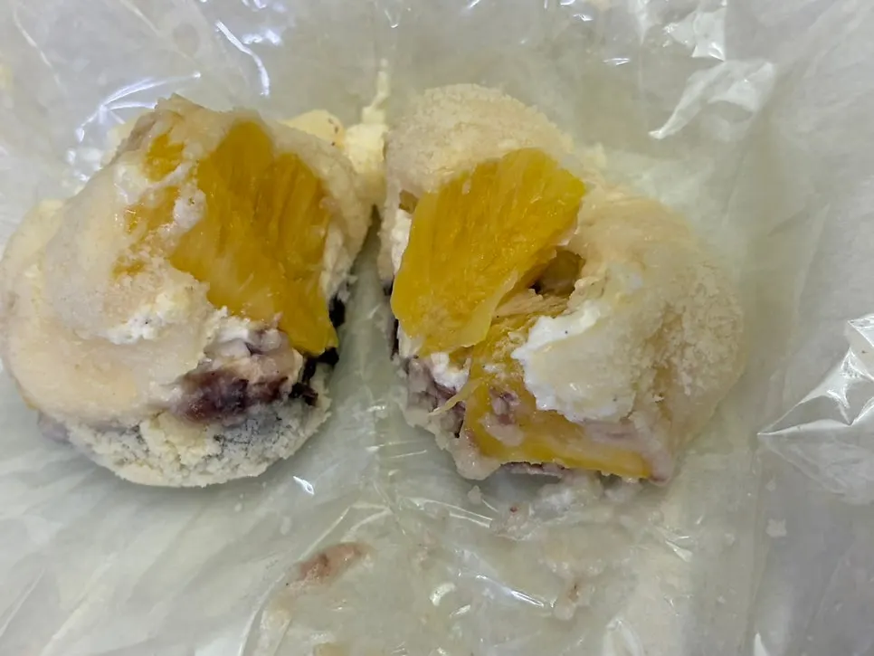 Close-up of a giant fruit mochi that has softened and melted out of shape