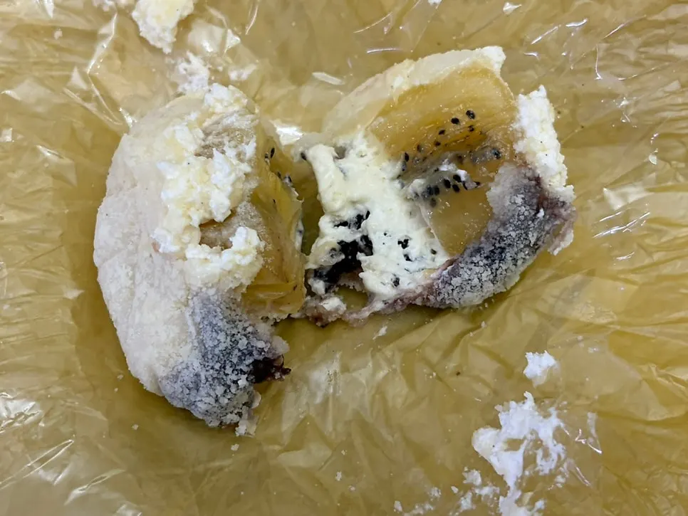 A pineapple mochi with a bite taken out of it