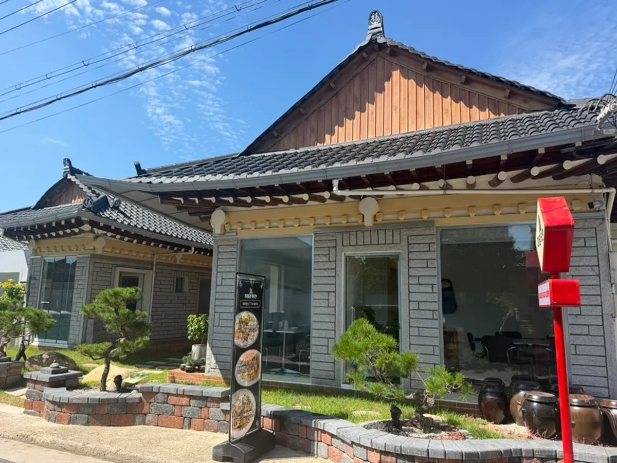 Exterior of Midam Kitchen with a hanok and lawn
