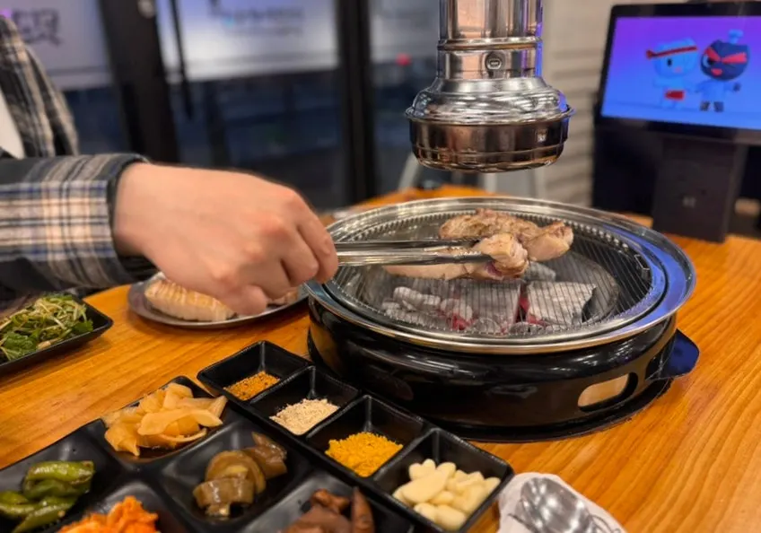 초벌해 나온 고기를 숯불 불판에 올린 모습