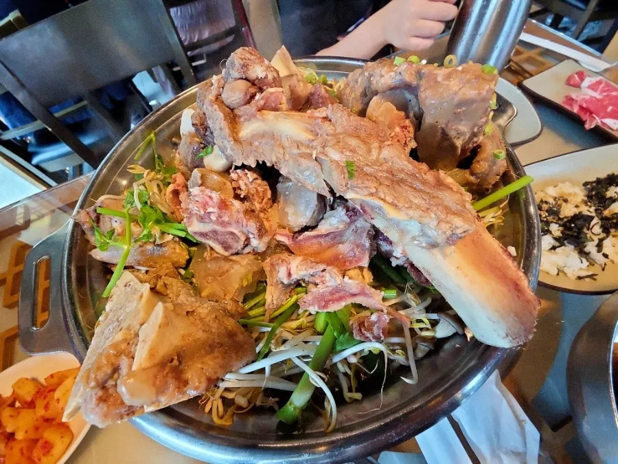 A full hot pot spread loaded with minari and bean sprouts