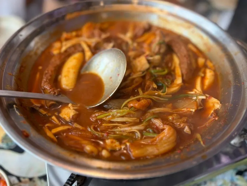Pork back-rib stew simmering with kimchi lifted on top