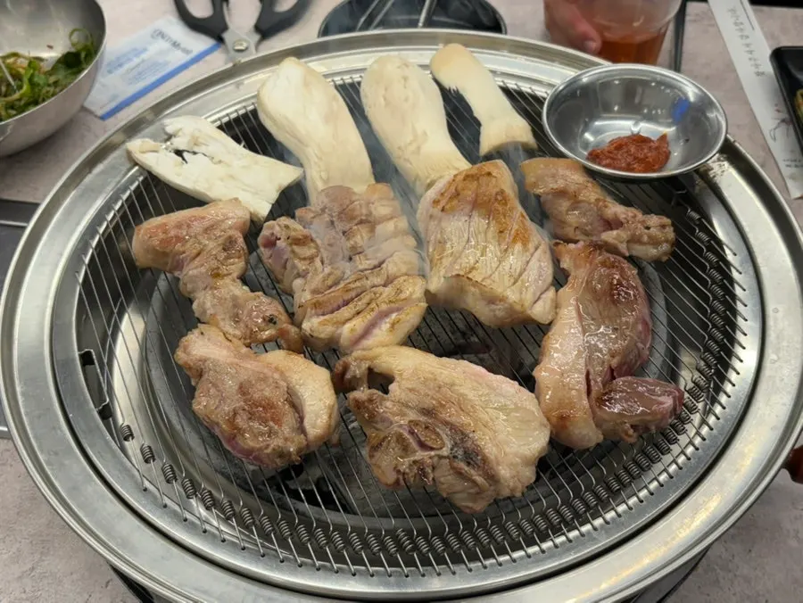 숯불 위에 올린 두툼한 뒷고기 덩어리