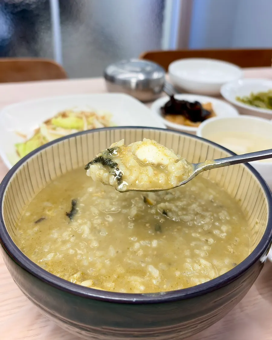 A spoonful of abalone porridge with a piece of abalone