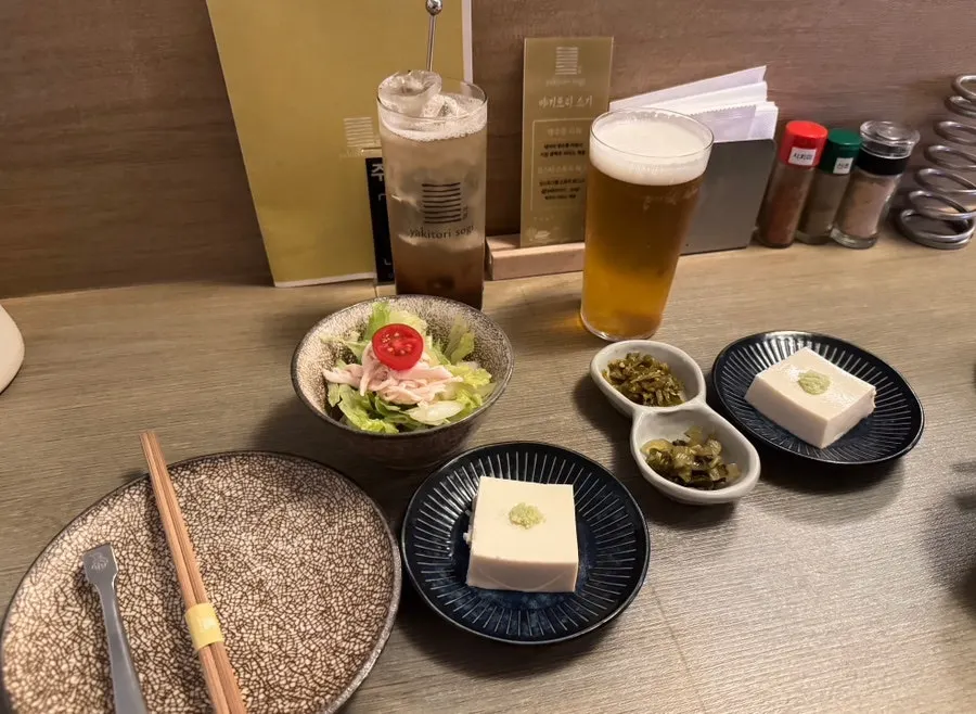 Starter banchan of pickled takana and pickled peppers with Kirin draft beer