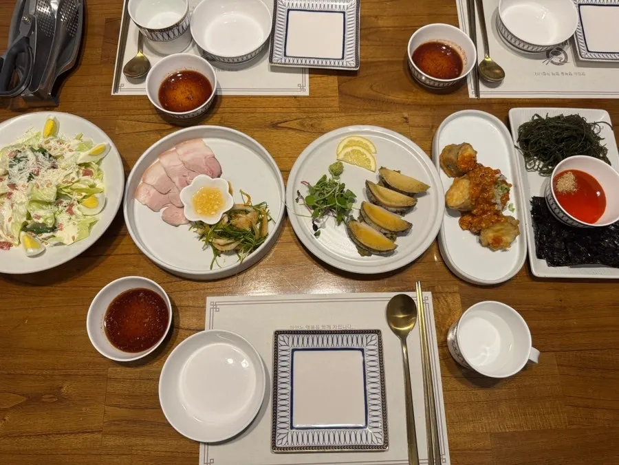 Bapeul Jitda set table including abalone and chilled pork