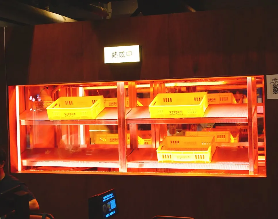 Meat-aging cabinet with red lighting in the center of the restaurant
