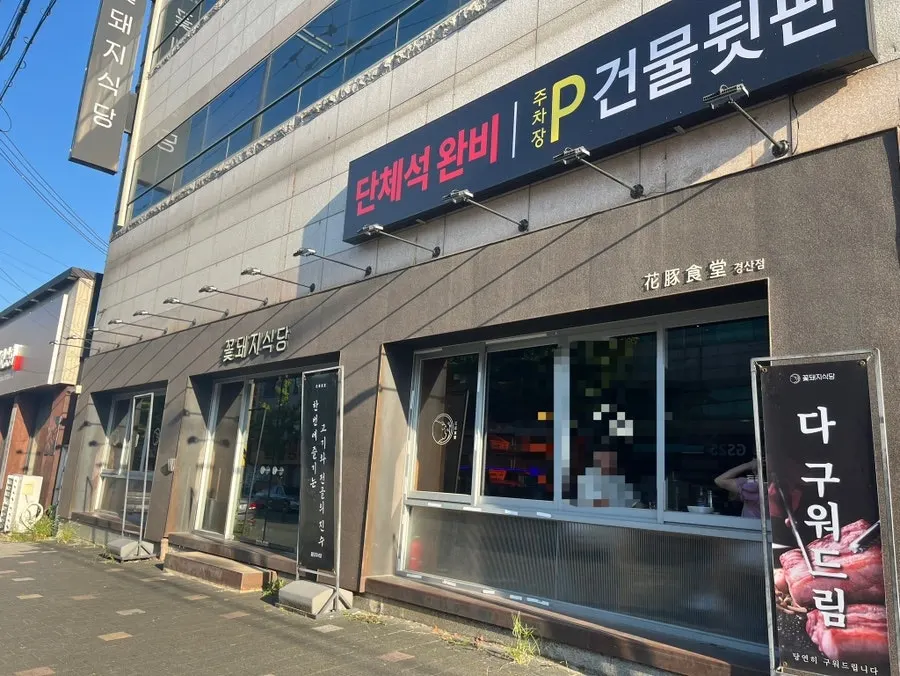 단체석 완비와 건물 뒷편 주차장이 적힌 가게 외부