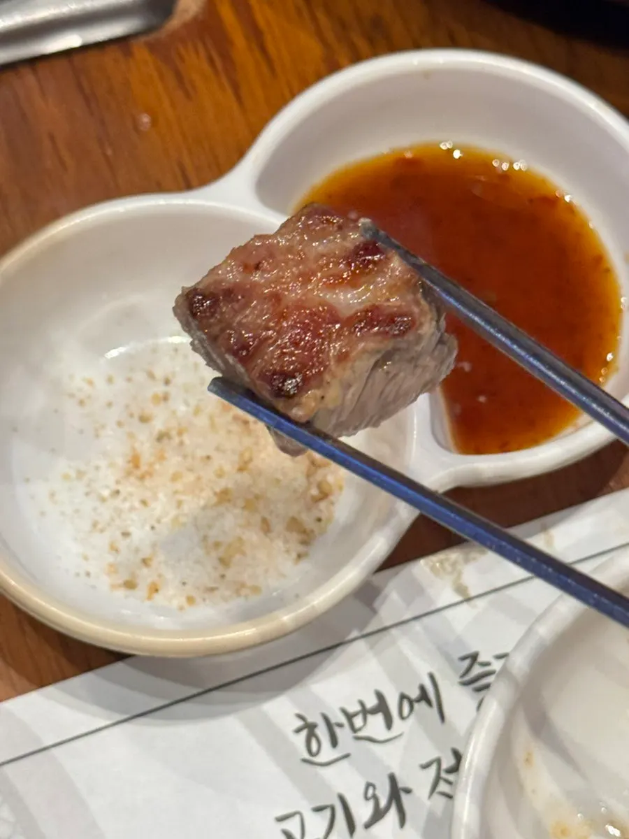 Meat grilling on the griddle alongside four kinds of stir-fried kimchi