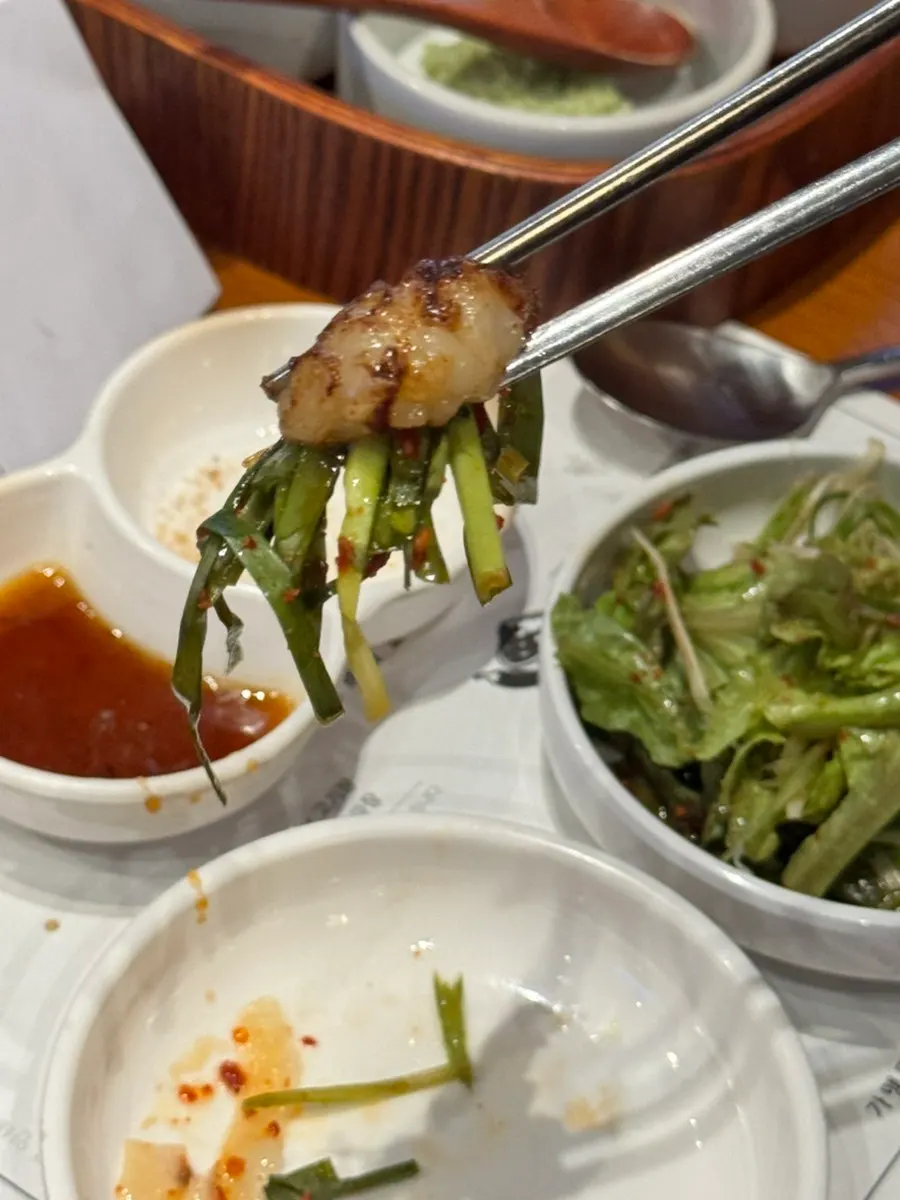 A piece of daechang paired with onion sauce