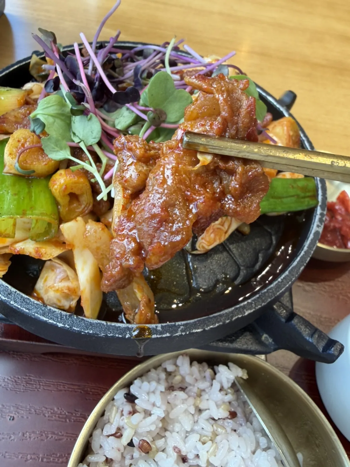 Flame-grilled pork bulgogi heating on the individual brazier