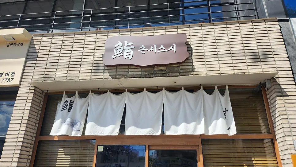 벽돌 건물에 鮨 손시스시 간판이 걸린 영남대 본점 외관