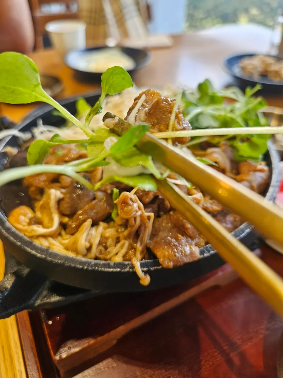 Chopsticks lifting a piece of jeyuk-bokkeum