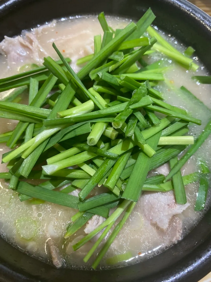 Stone bowl of soup with radish kimchi brine added
