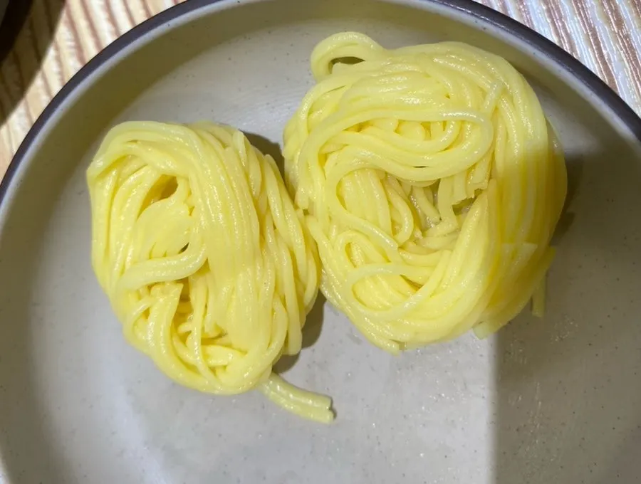 Yellow thin noodles added to the pork soup
