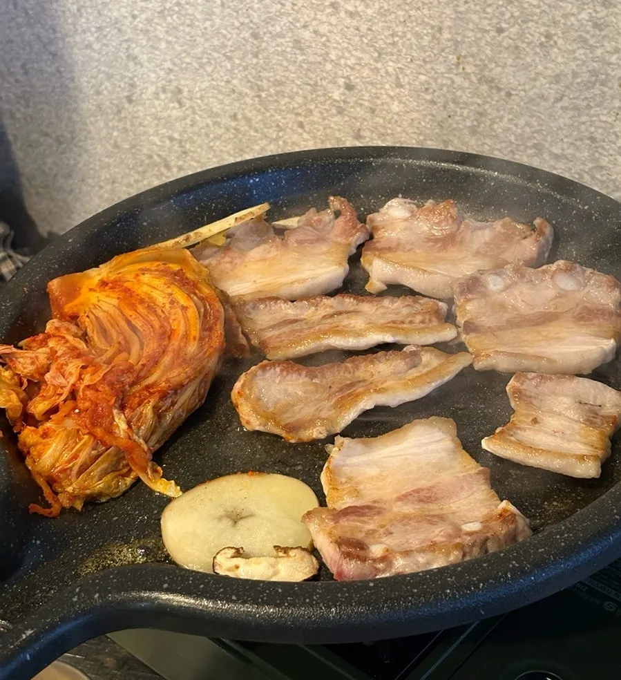 Pork belly sizzling on the grill