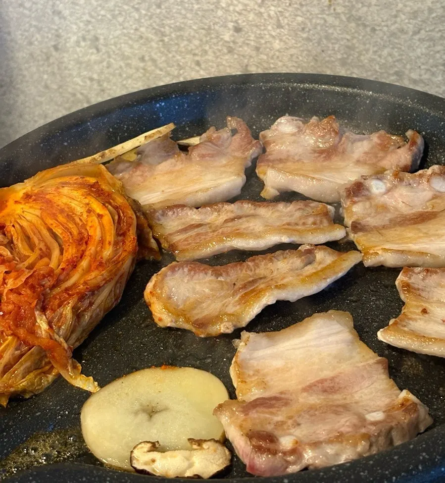 Pork belly grilling with side vegetables