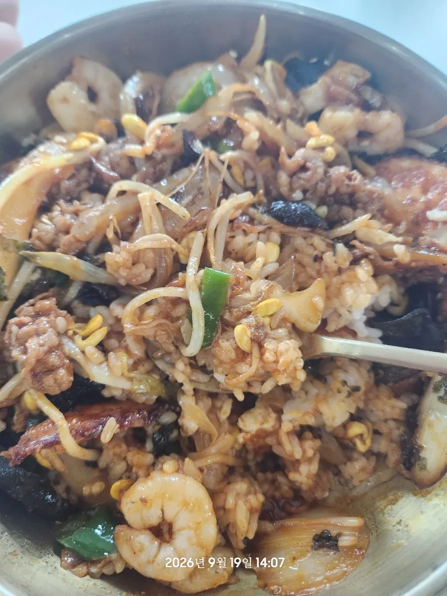 Close-up of the junghwa bibimbap topped with seafood and meat