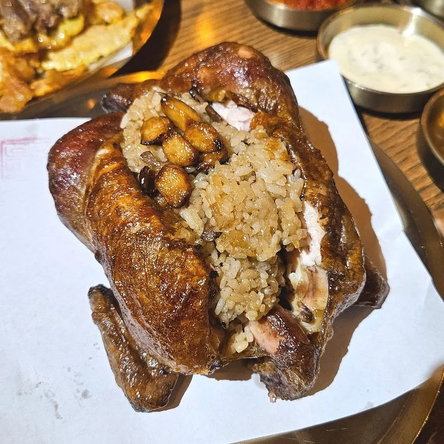 Table spread of Gyeryugwan's signature oak and neungi mushroom fire-roasted chicken