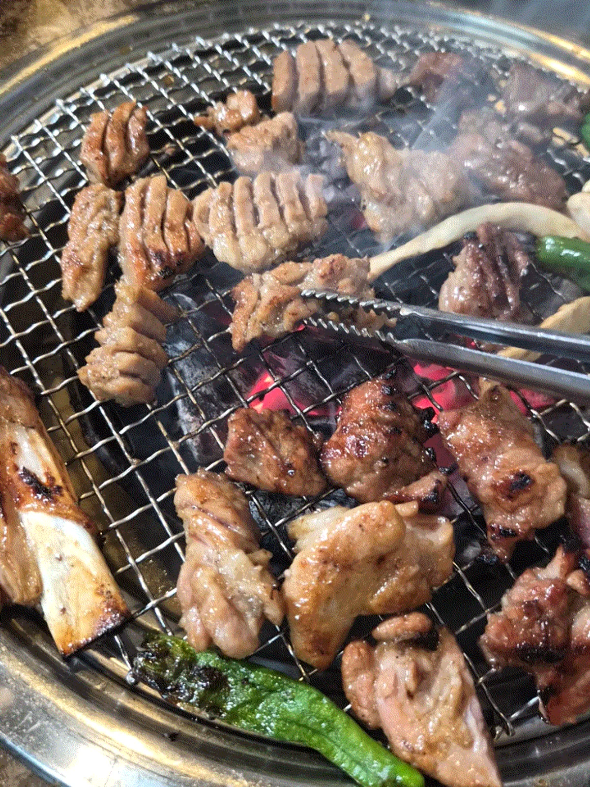 Seasoned pork ribs turning golden brown over the charcoal grill