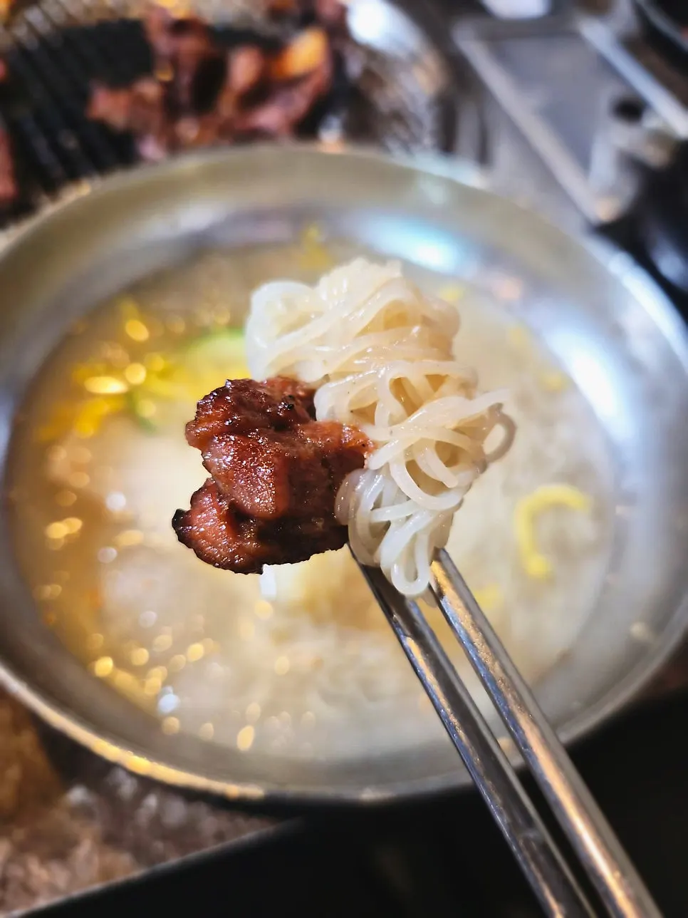 A bowl of mul naengmyeon with floating slush ice