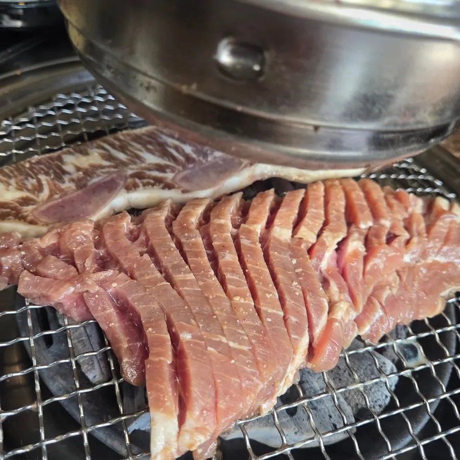 Marinated ribs grilling to a golden brown over charcoal
