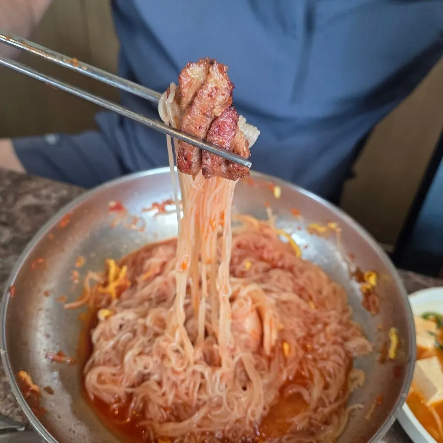 Noodle strands tossed with spicy sauce in bibim naengmyeon