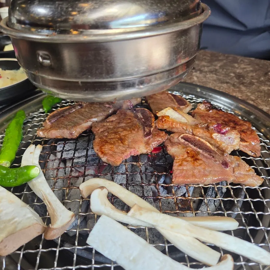 A piece of galbi placed on top of the bibim naengmyeon