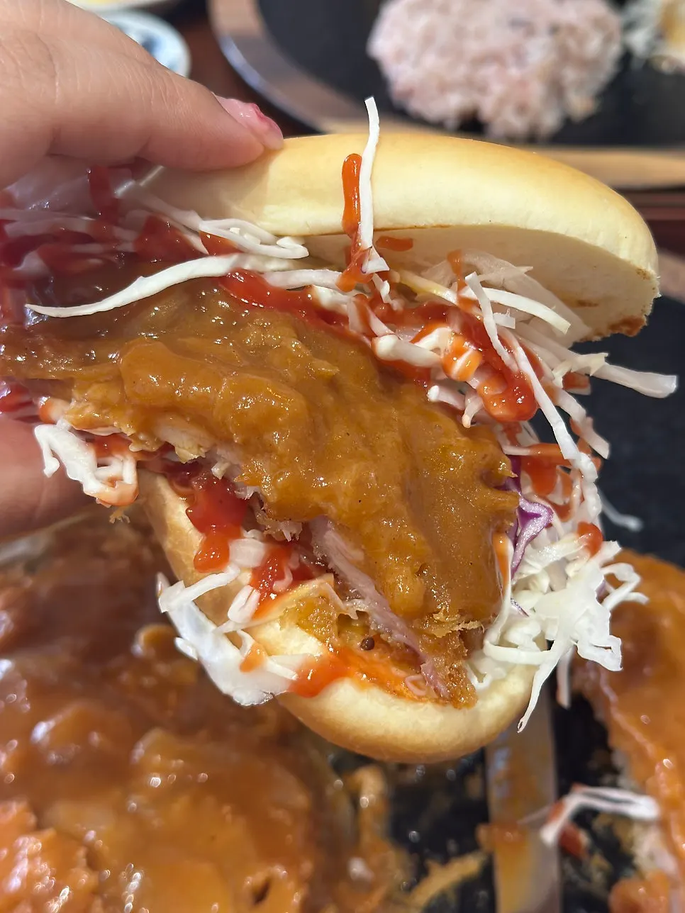 A piece of chicken cutlet dipped in sauce