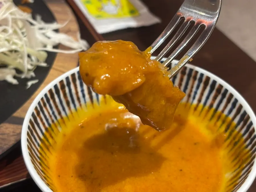 돈까스에 버터치킨카레를 찍는 모습