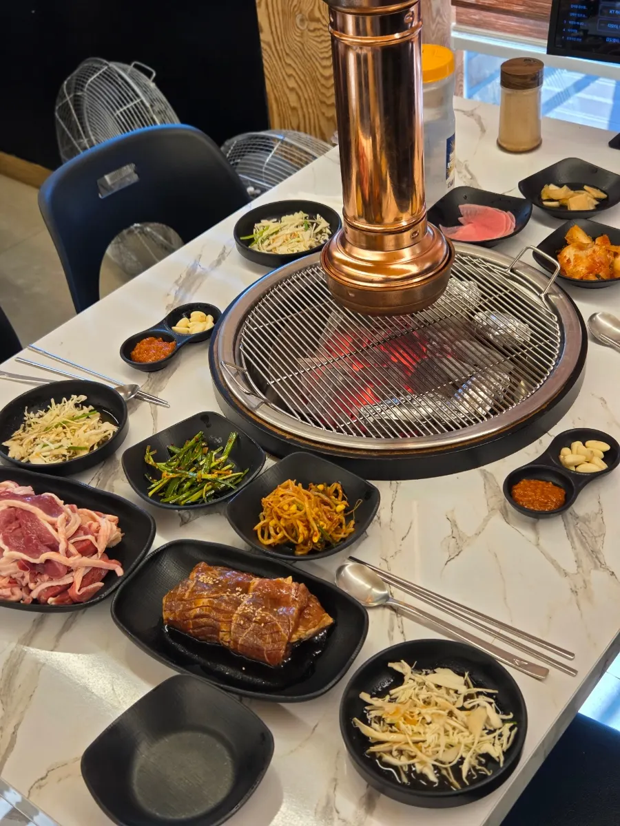 Full table setting with fresh duck charcoal grill and side dishes