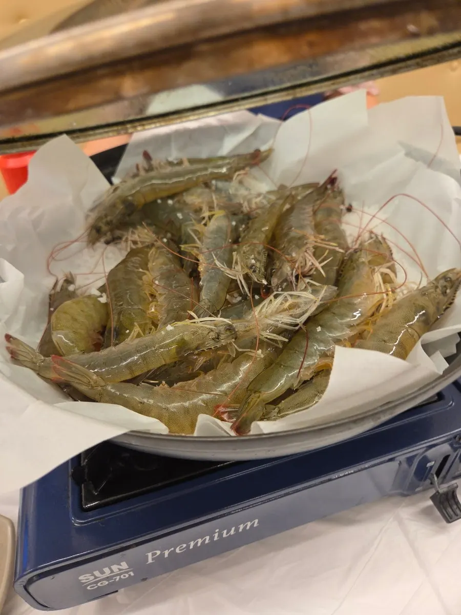 Prawns grilling on a bed of salt
