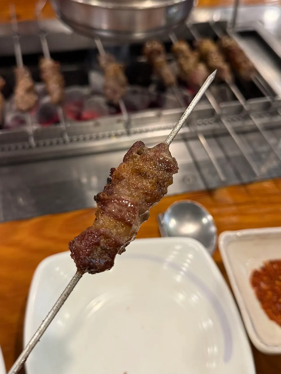 Lamb tenderloin skewers grilling over charcoal
