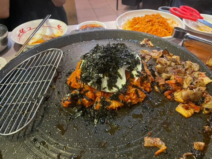Fried rice topped with a fried egg and seaweed flakes
