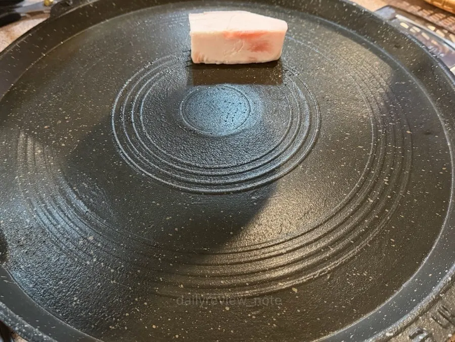 Thin-sliced pork cooking on the grill