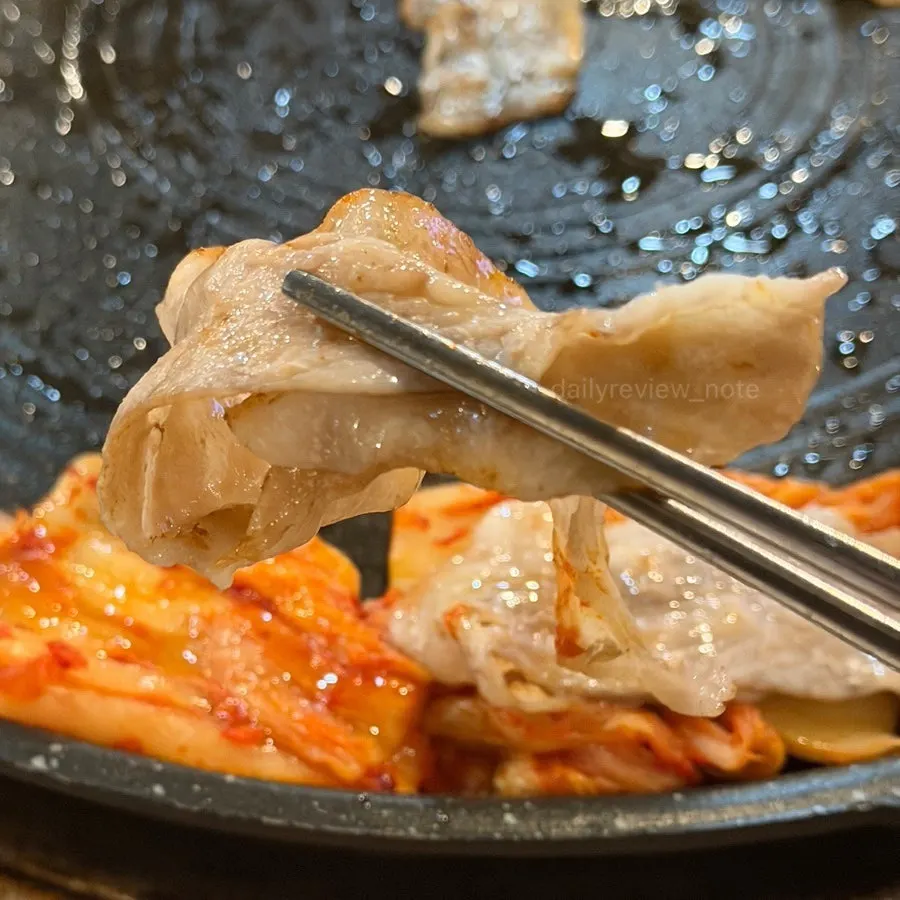 Thin-sliced pork belly cooking on the grill