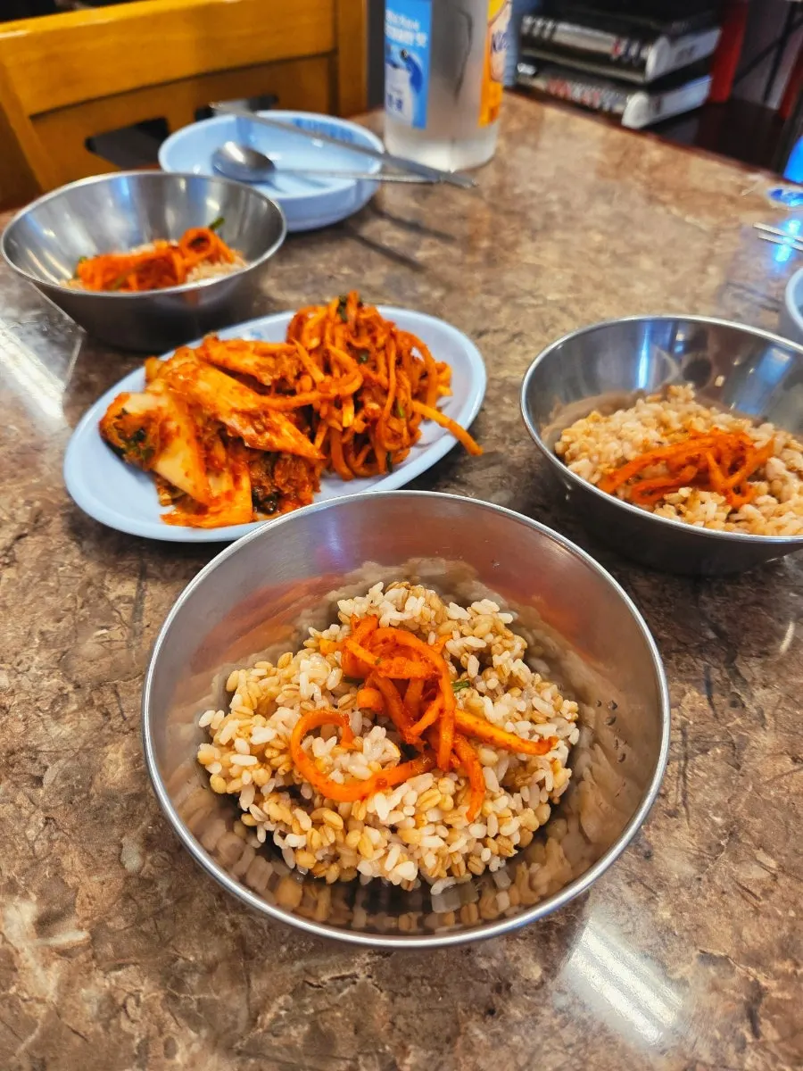 Barley rice bibimbap topped with radish salad and seasoning sauce