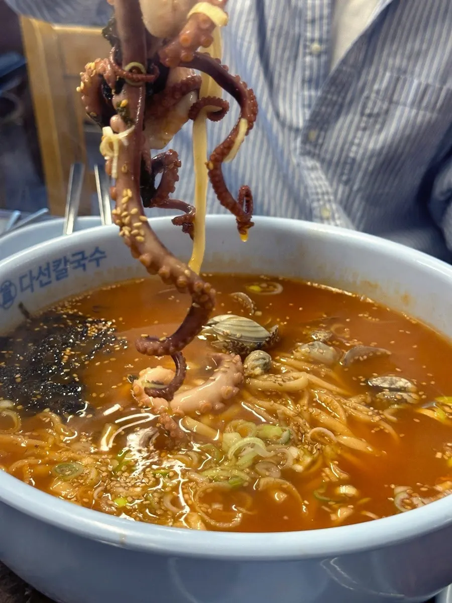 Kalguksu noodles mixed into the spicy broth