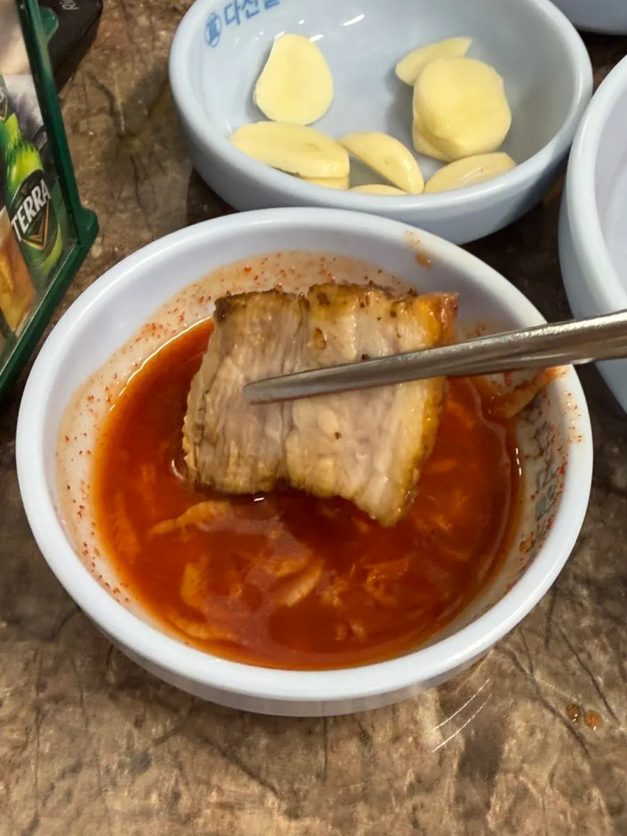 부추를 올려 집어 든 수육 한 점