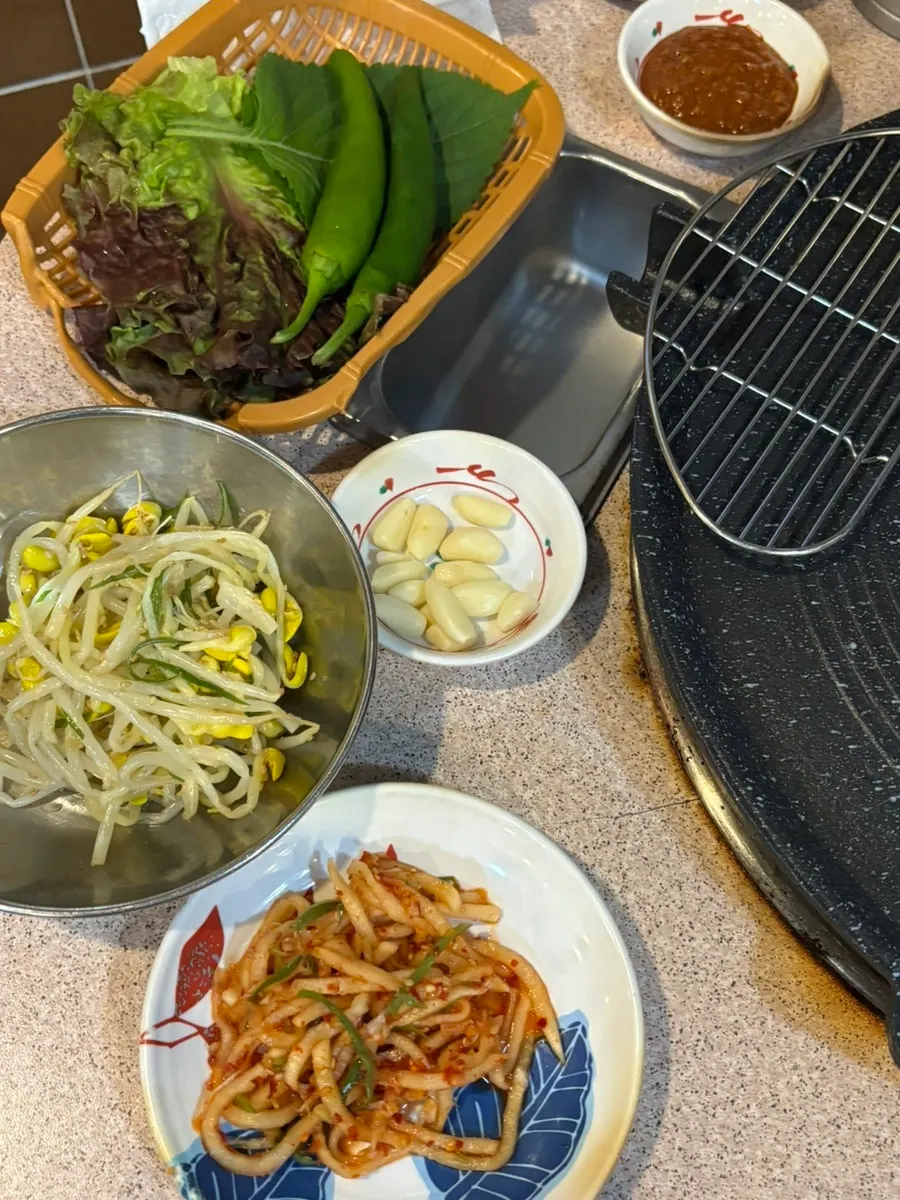 Gyodaepae's basic side dishes including ssam vegetables and seasoned bean sprouts