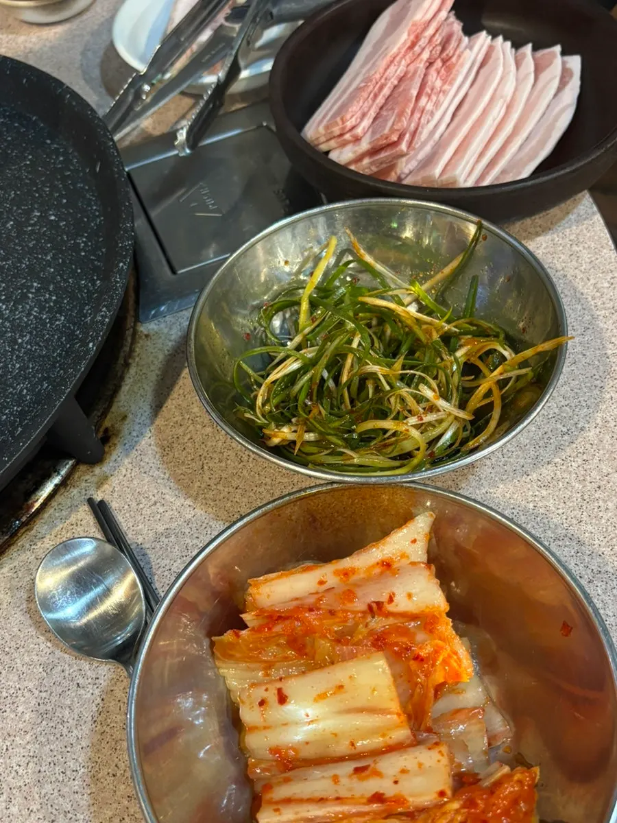 Table set with pickled scallions and special sauce alongside the meat